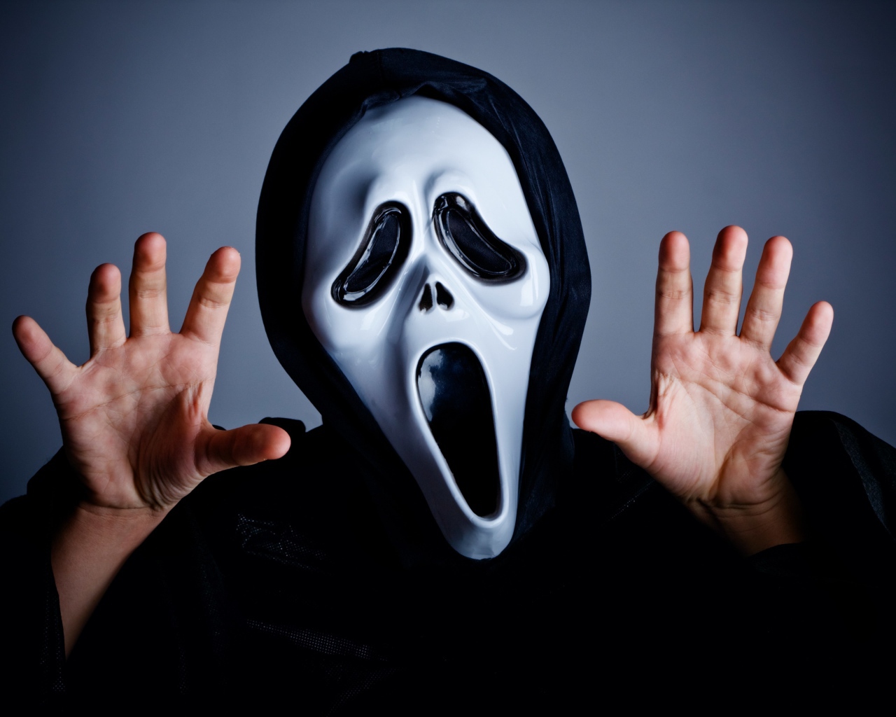 Мужчина в маске пугает на сером фоне