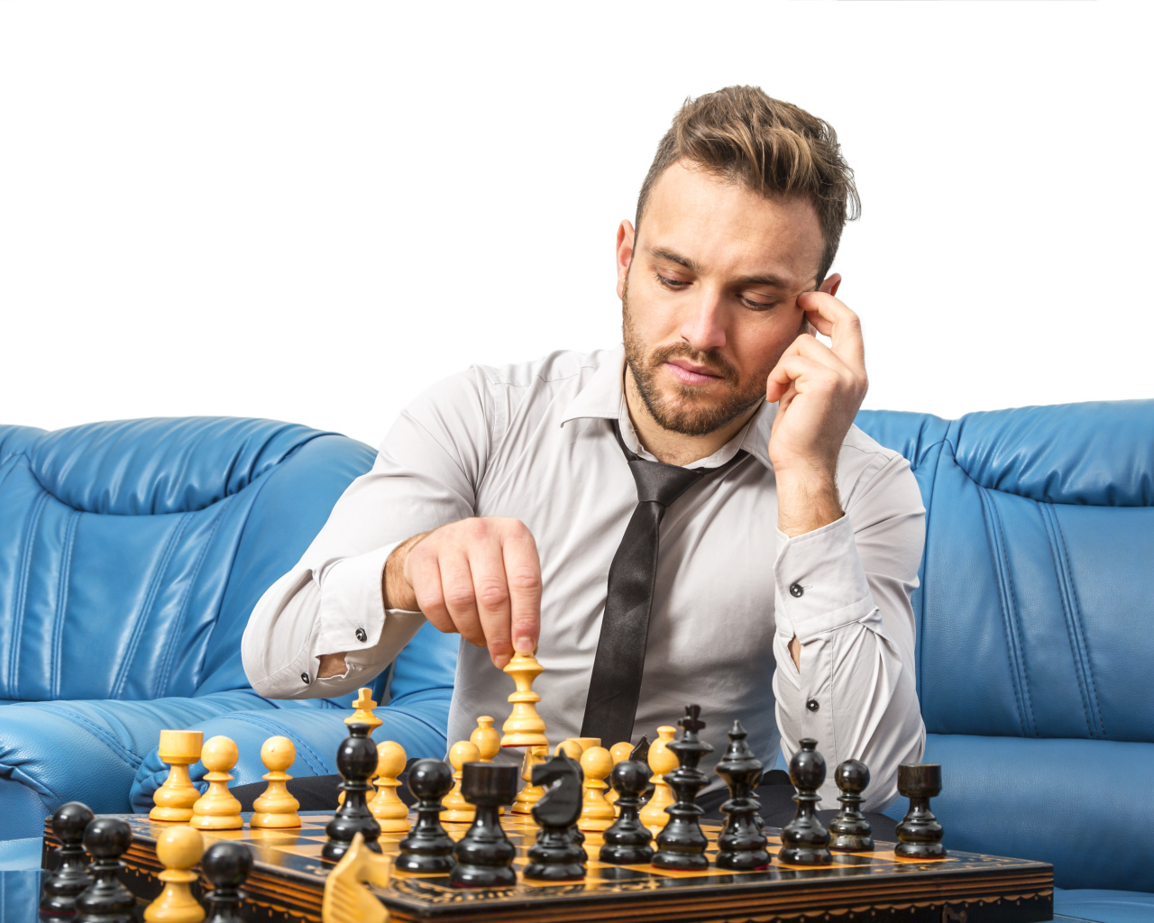 Мужчина играет в шахматы на синем диване