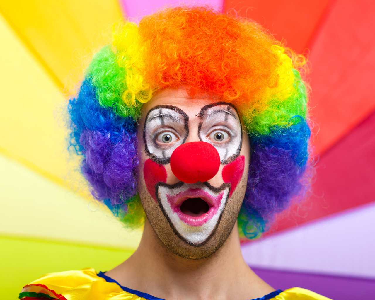 Удивленный мужчина в костюме клоуна 