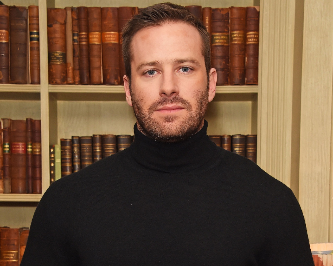 Актер Арми Хаммер стоит у библиотеки