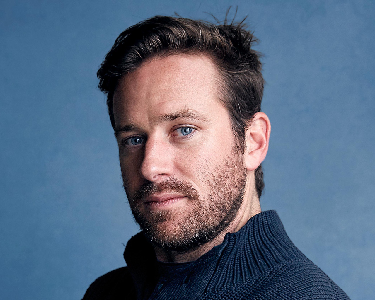 Актер Арми Хаммер на голубом фоне