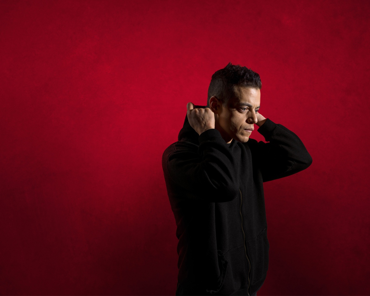 Актер Рами Малек на красном фоне