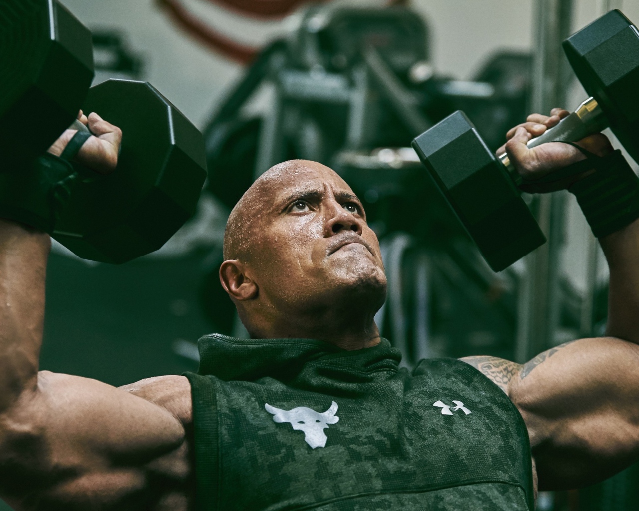 Американский актер, сильный мужчина Дуэйн Джонсон с гантелями в спортзале