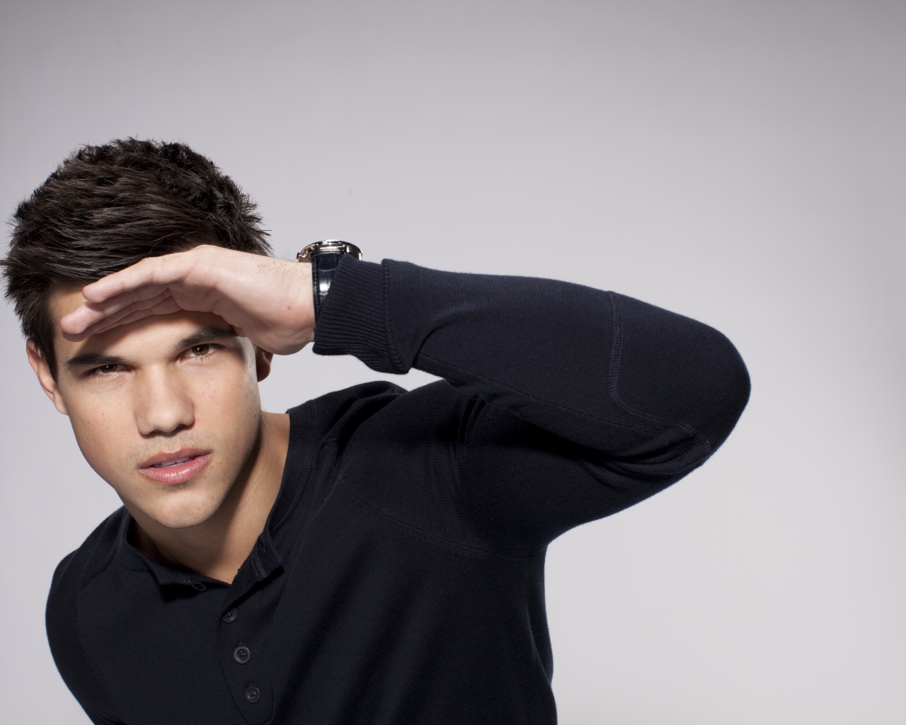 Красивый парень, актер Тейлор Лотнер на сером фоне