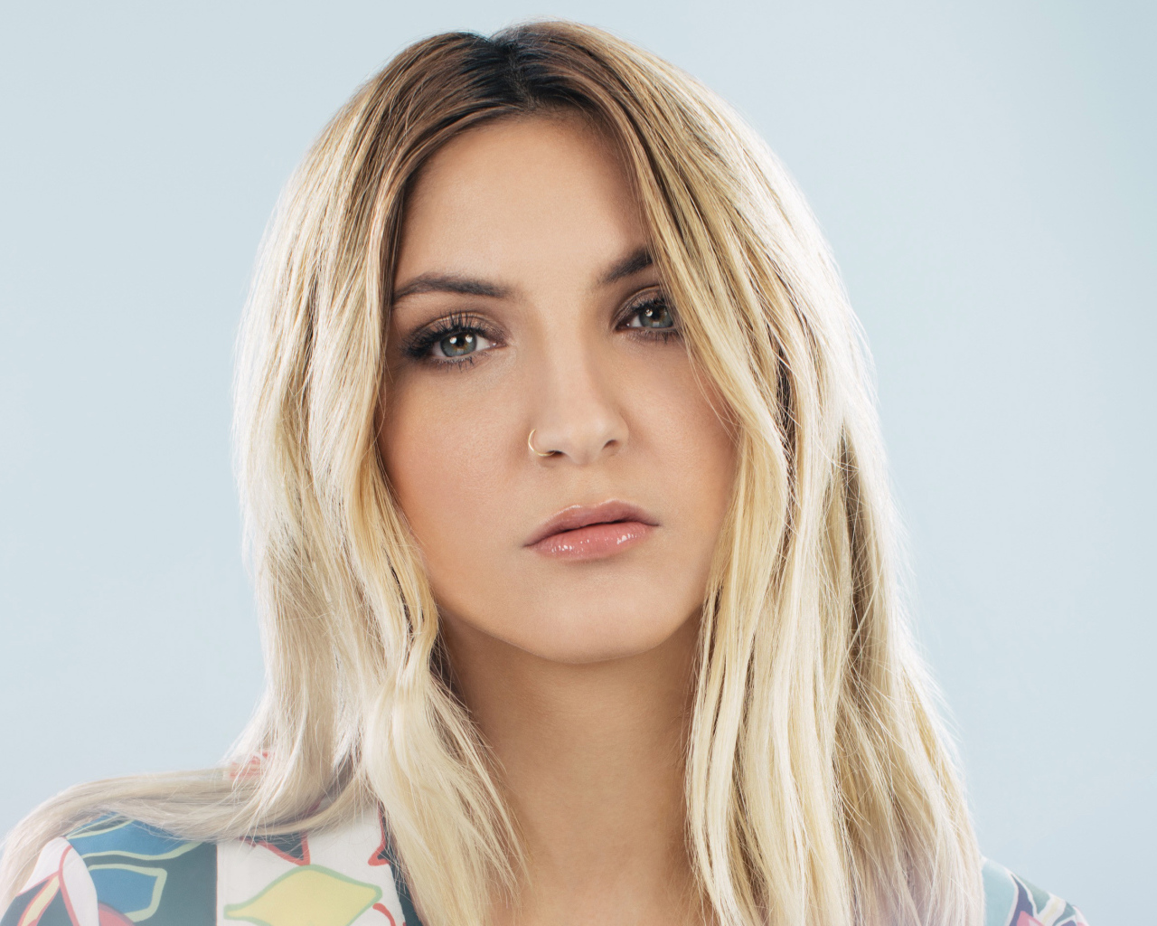 Красивая блондинка, певица Джулия Майклз на сером фоне