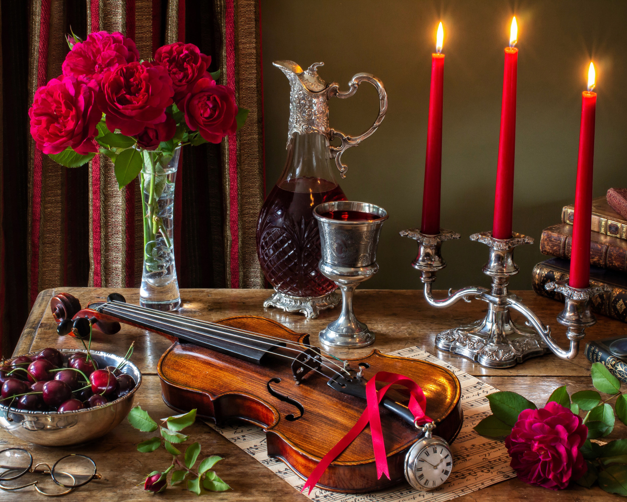 Зажженные красные свечи на столе букетом роз, скрипкой и черешней 