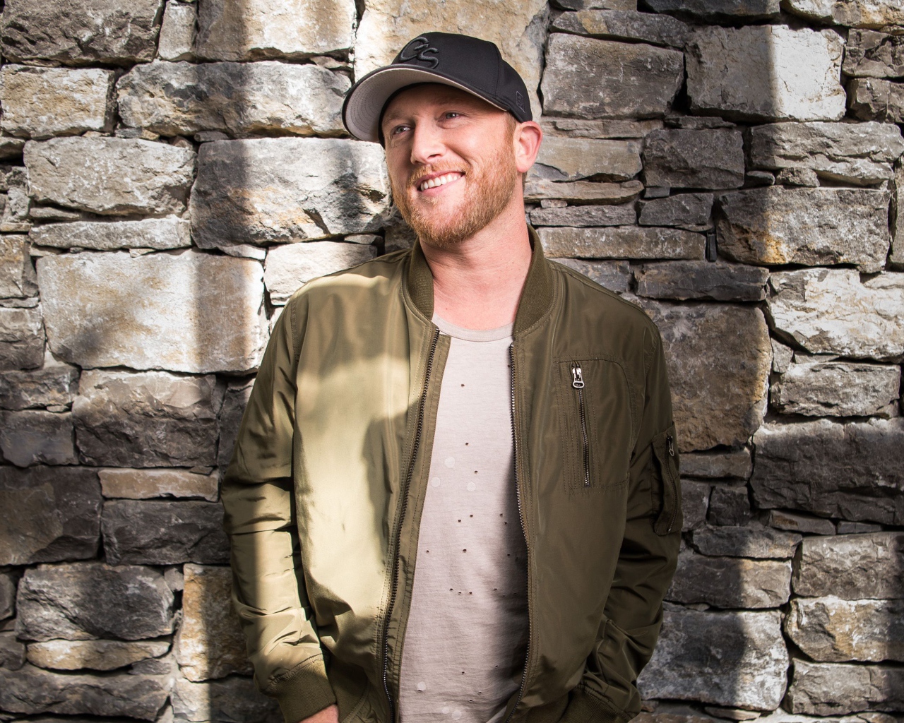 Музыкант Коул Суинделл в бейсболке у стены