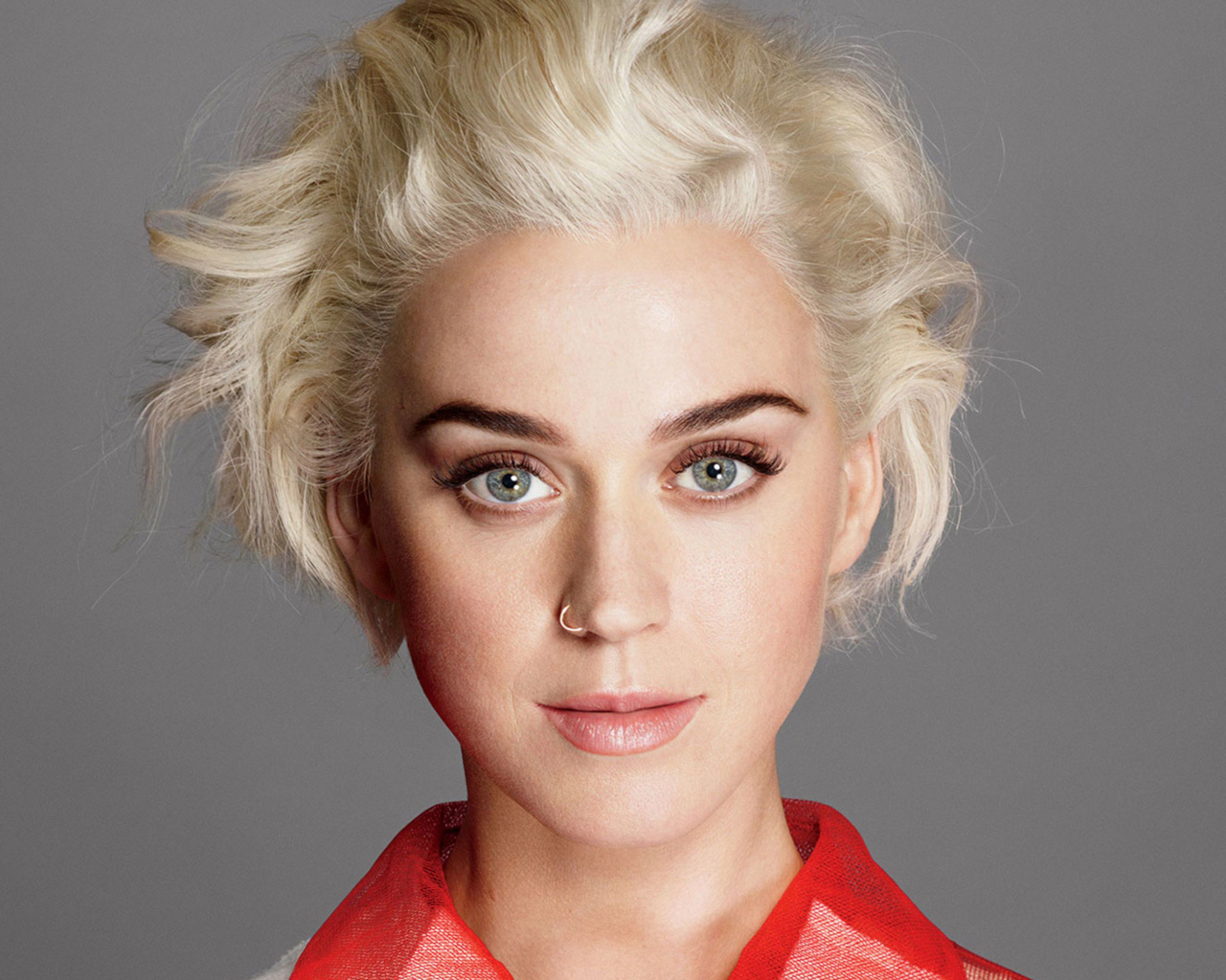 Певица Кэти Перри с короткой стрижкой на сером фоне