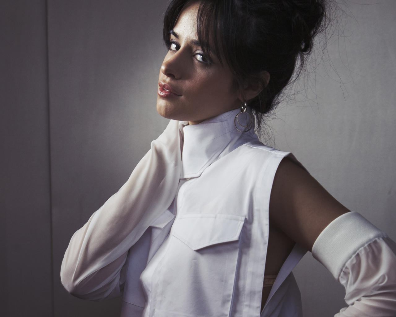 Молодая певица Камила Кабельо в белом костюме у стены