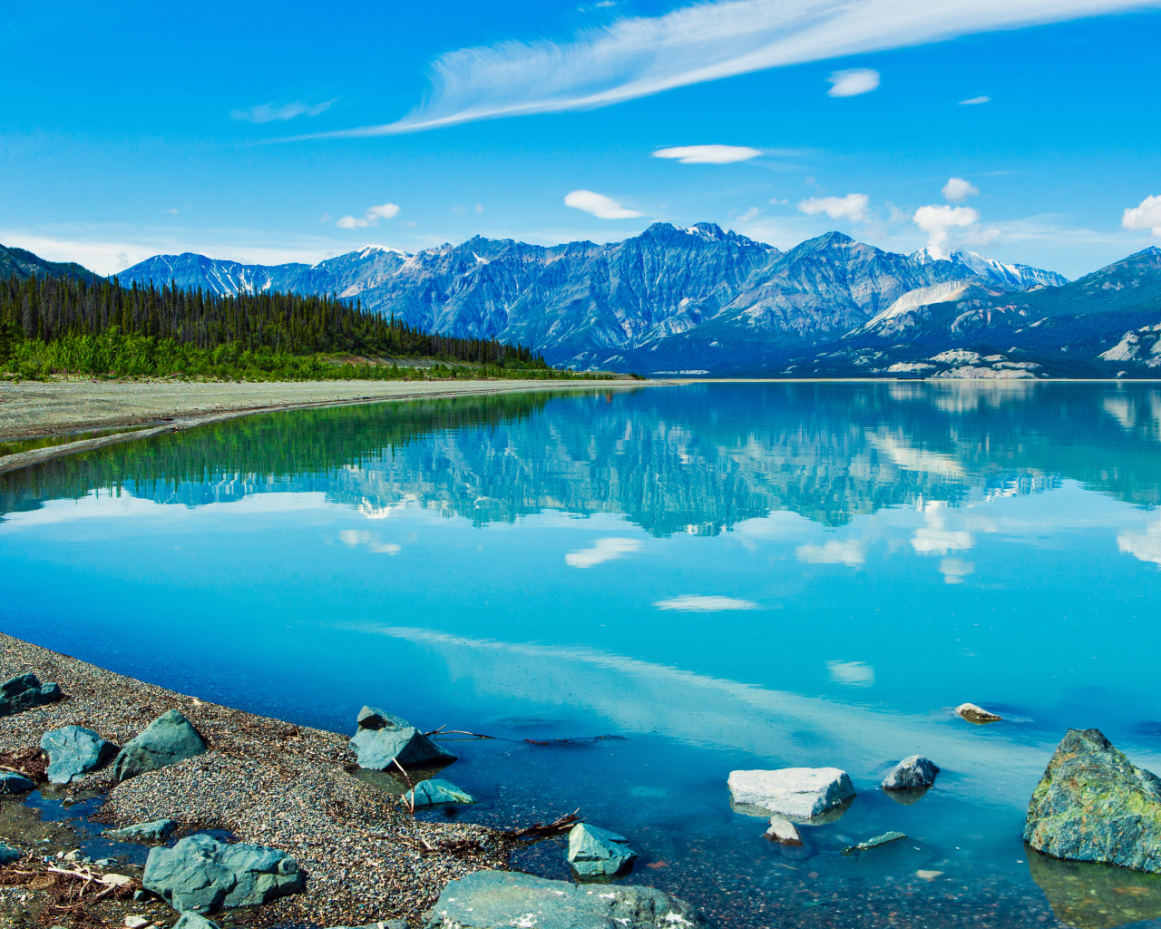 Красивое голубое озеро у заснеженных гор