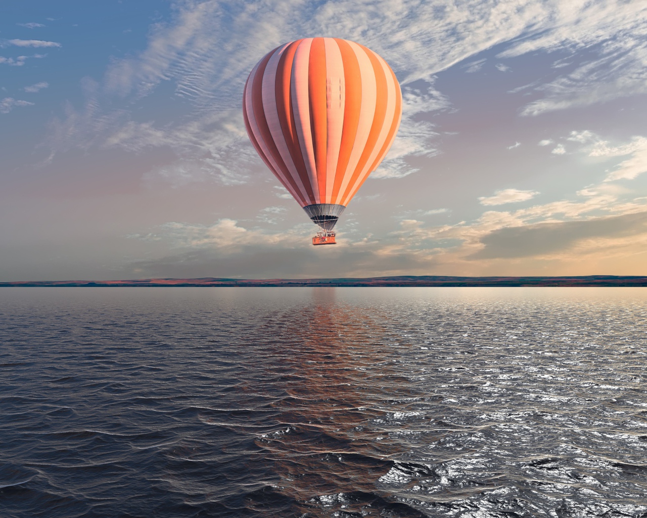 Большой оранжевый воздушный шар в небе над спокойной водой 