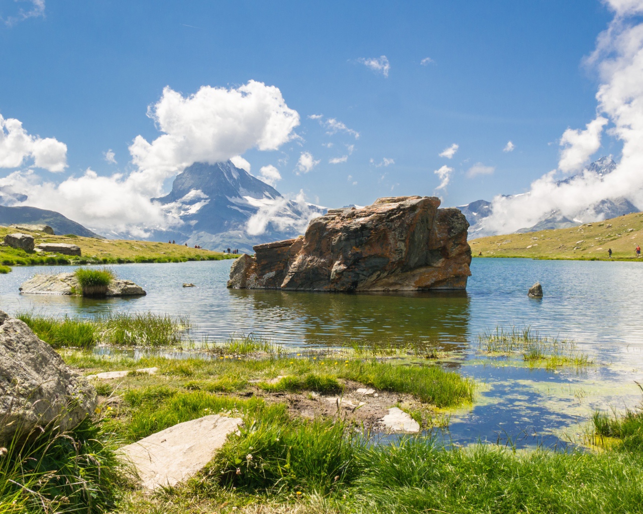Большой камень в воде на фоне голубого неба
