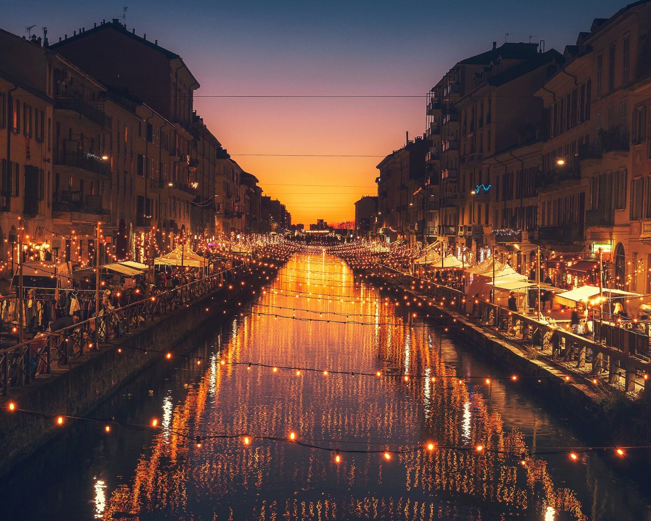 Яркие зажженные лампы над водным каналом