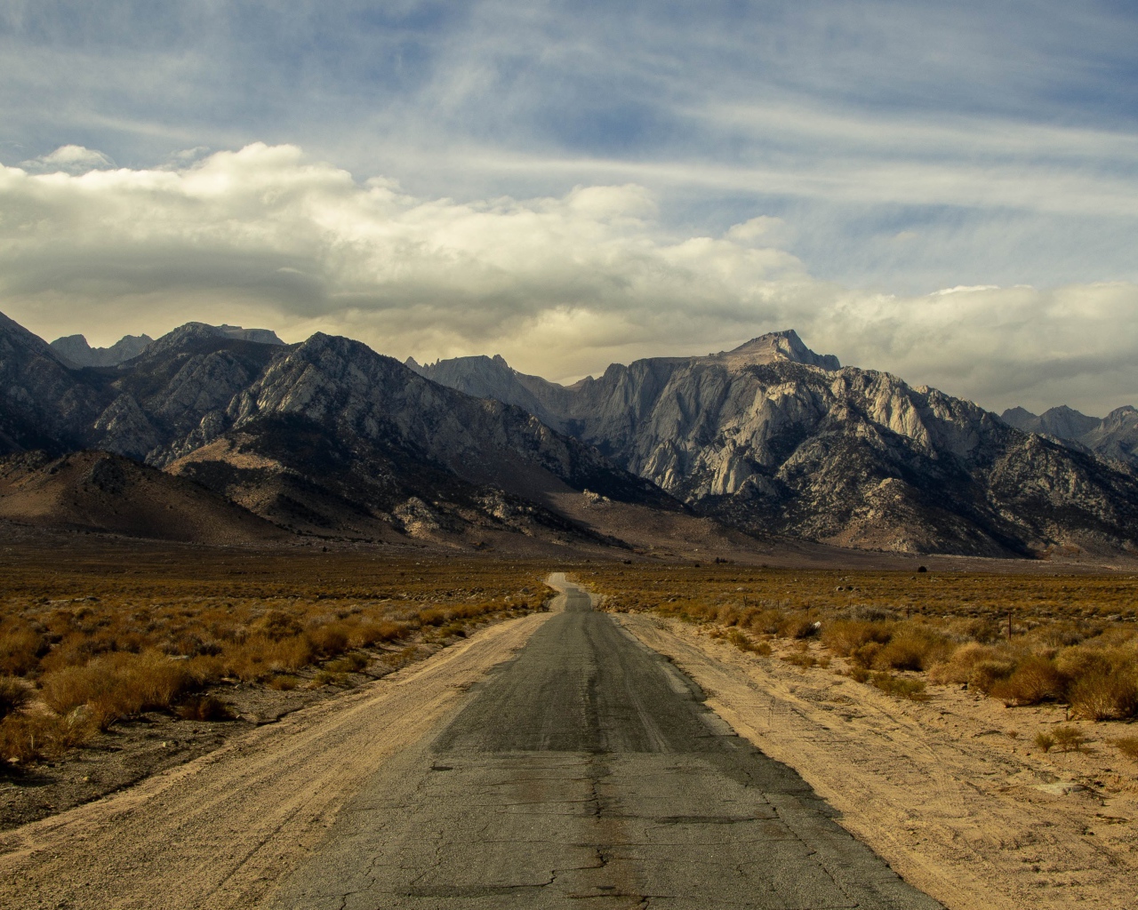 Long deserted road goes to the mountains