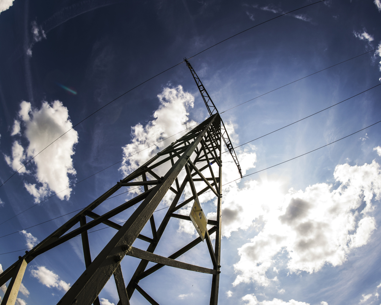 Столб линии электропередач на фоне голубого неба с облаками