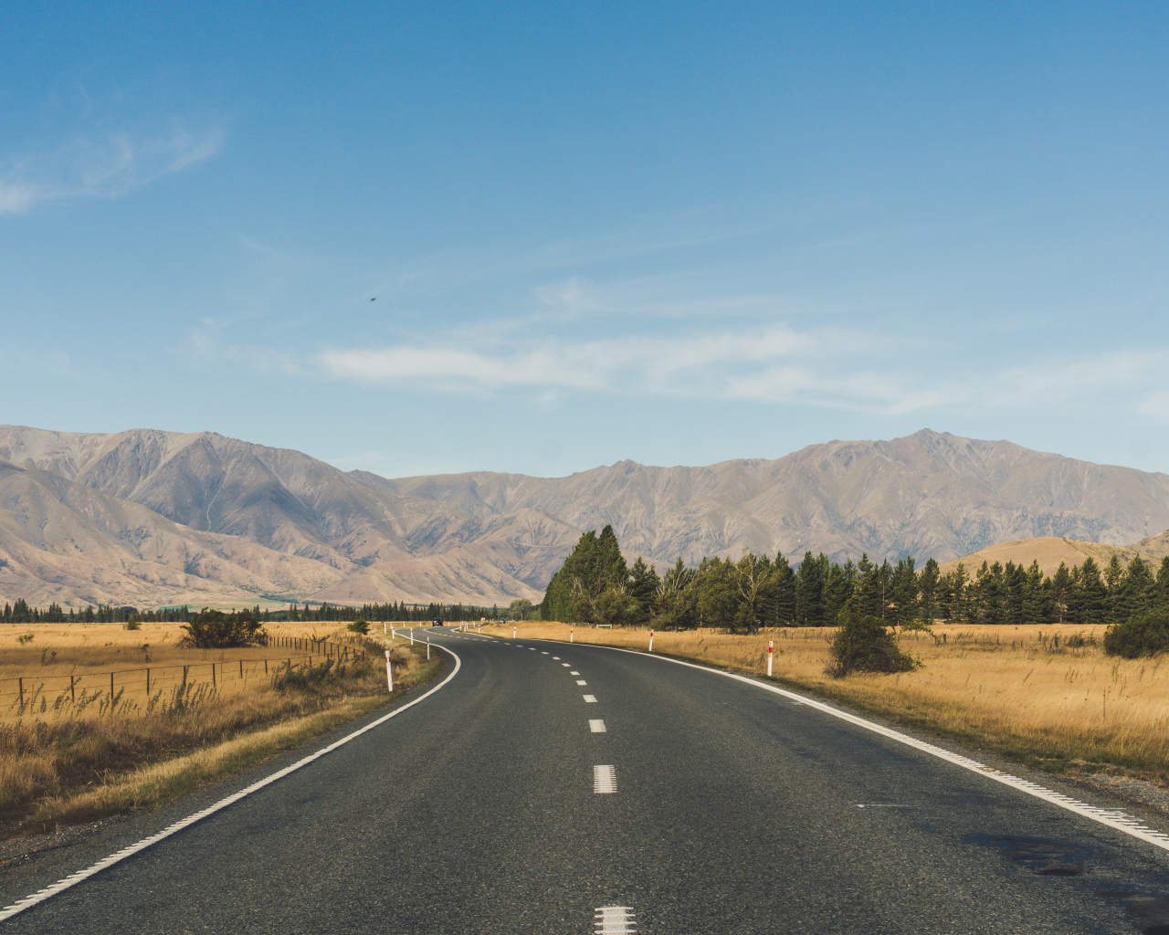 Ровная асфальтовая дорога на фоне гор 