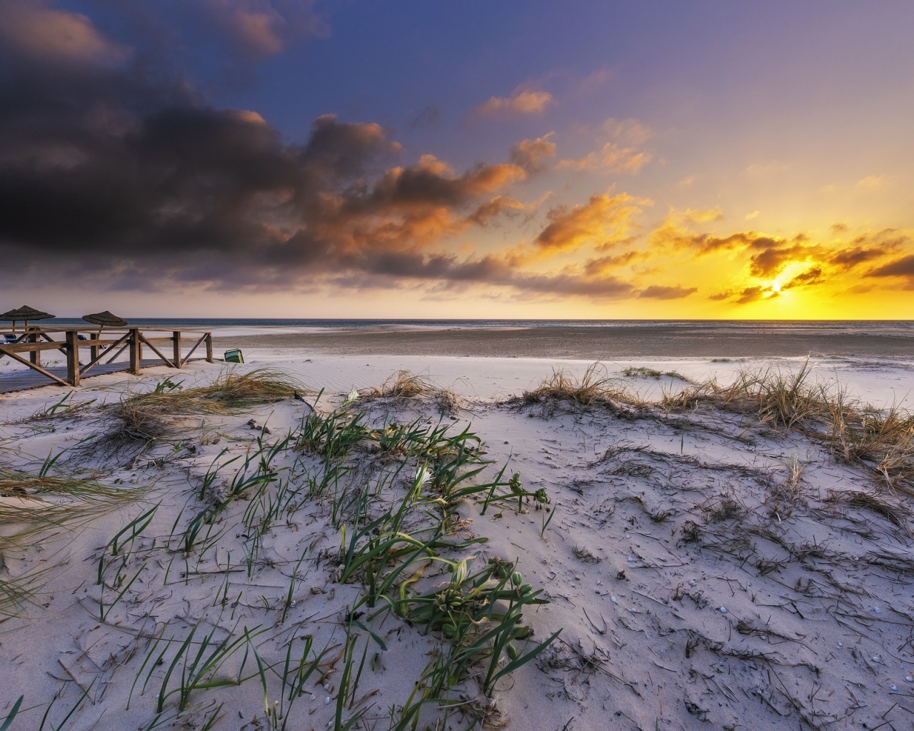 Белый песок в траве на берегу под красивым небом на закате