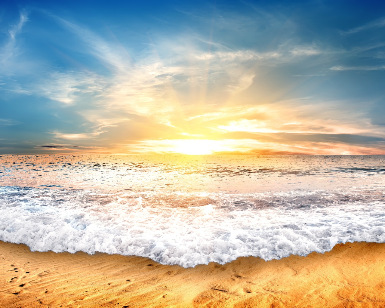 Белые волны на желтом песке на закате солнца 