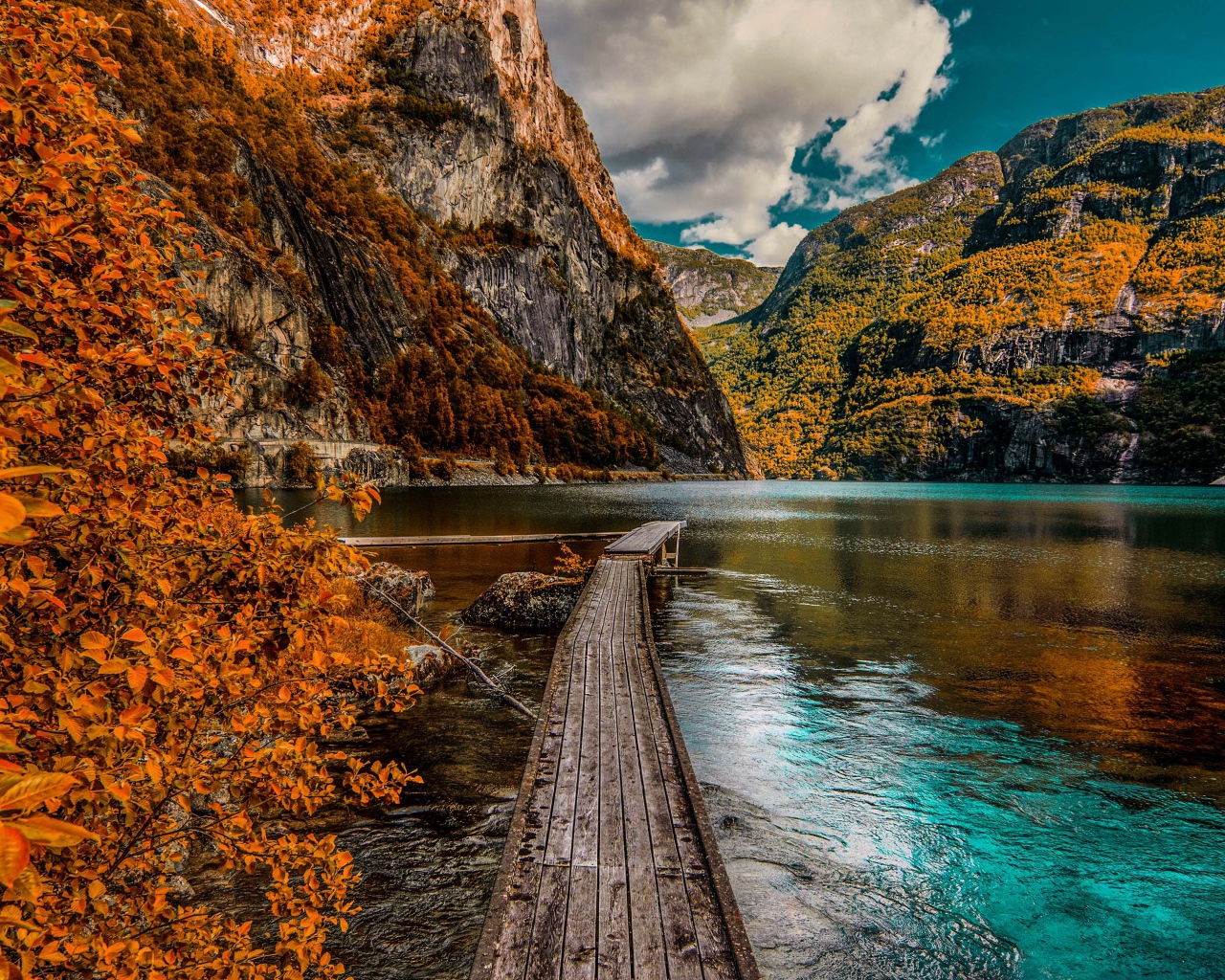 Деревянный мост в воде на фоне гор 