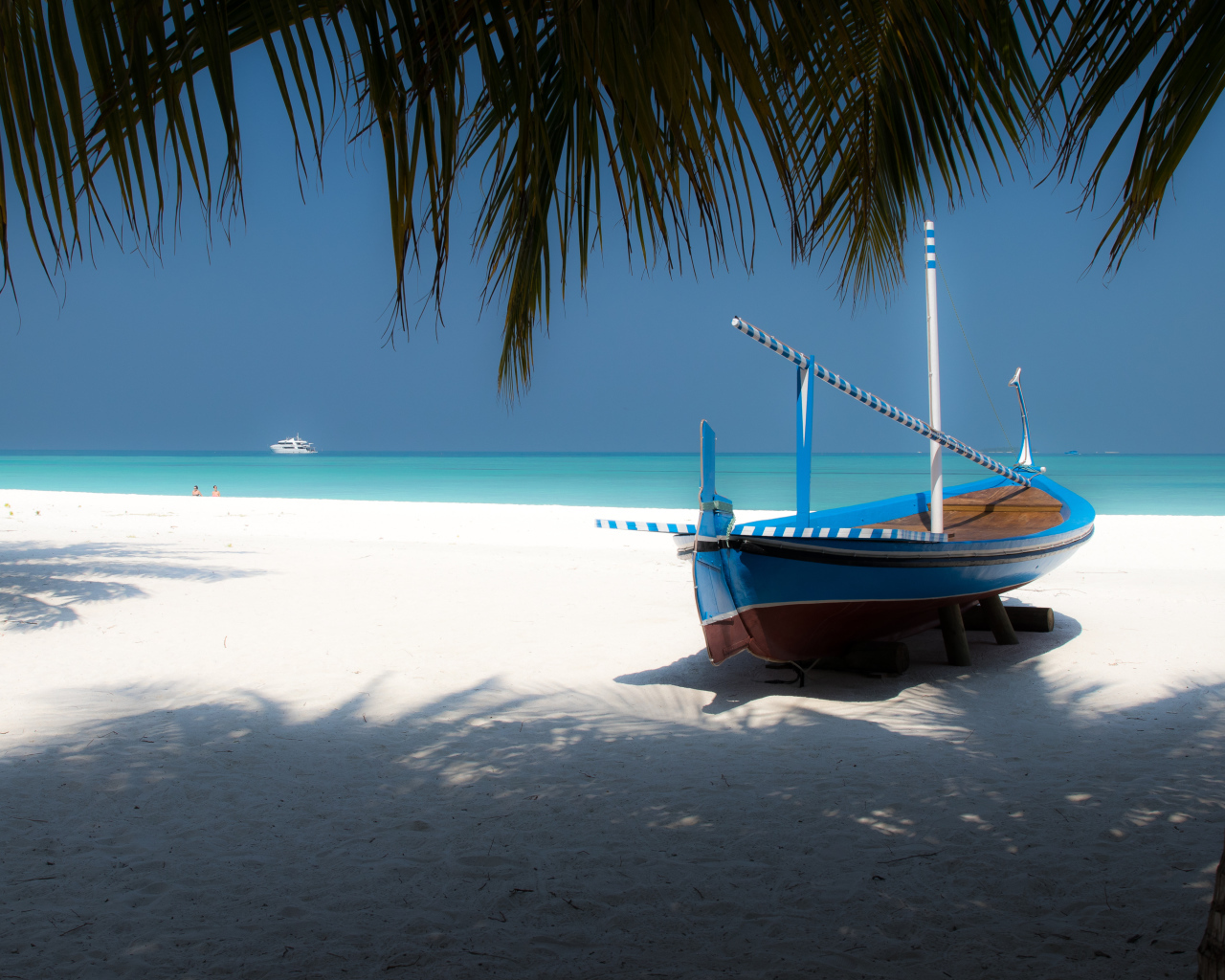 Лодка на белом песке у океана в тропиках