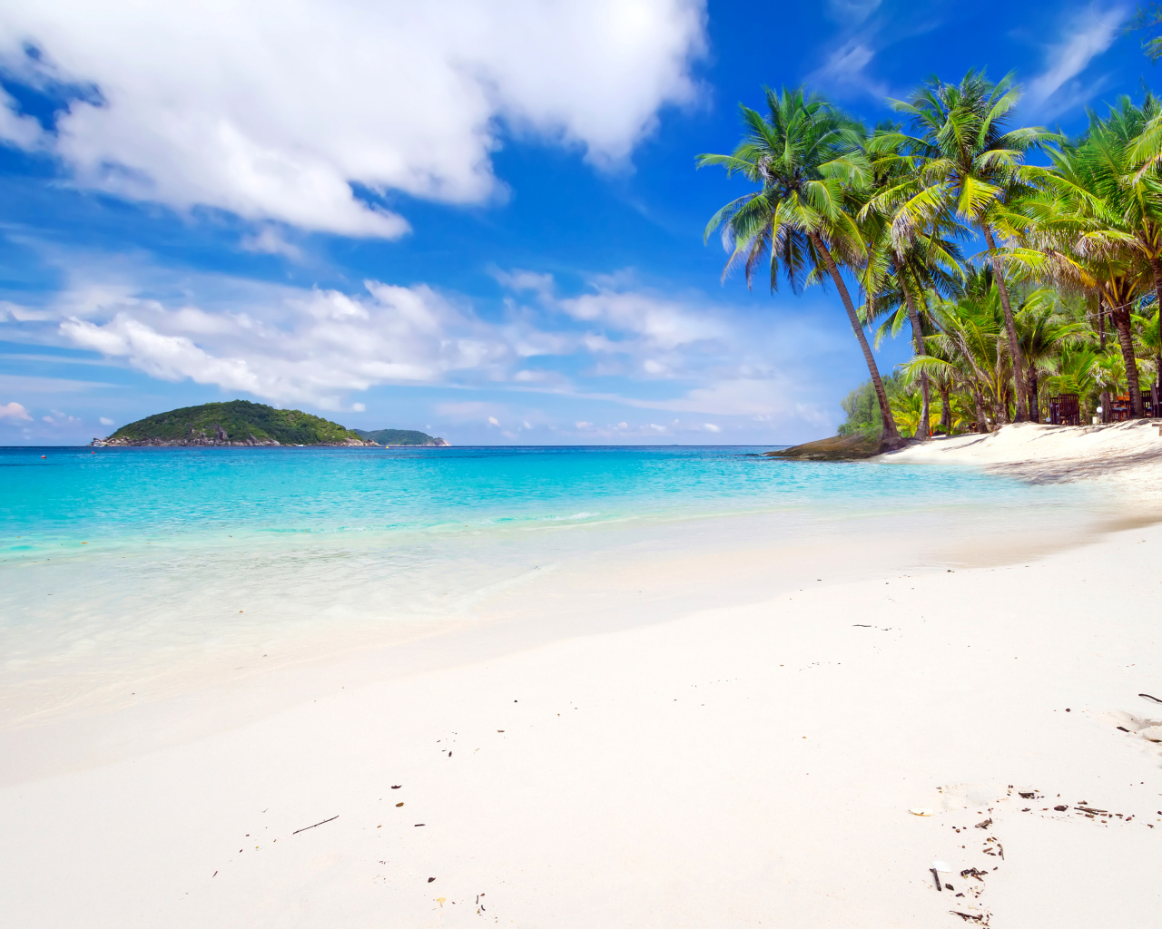 Белый песок на тропическом пляже с голубой водой 