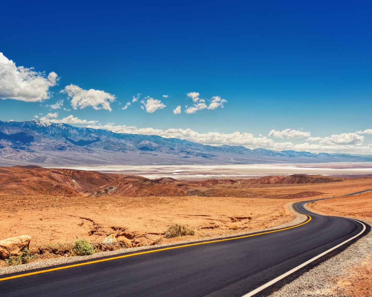 Дорога в пустыне под красивым голубым небом с белыми облаками