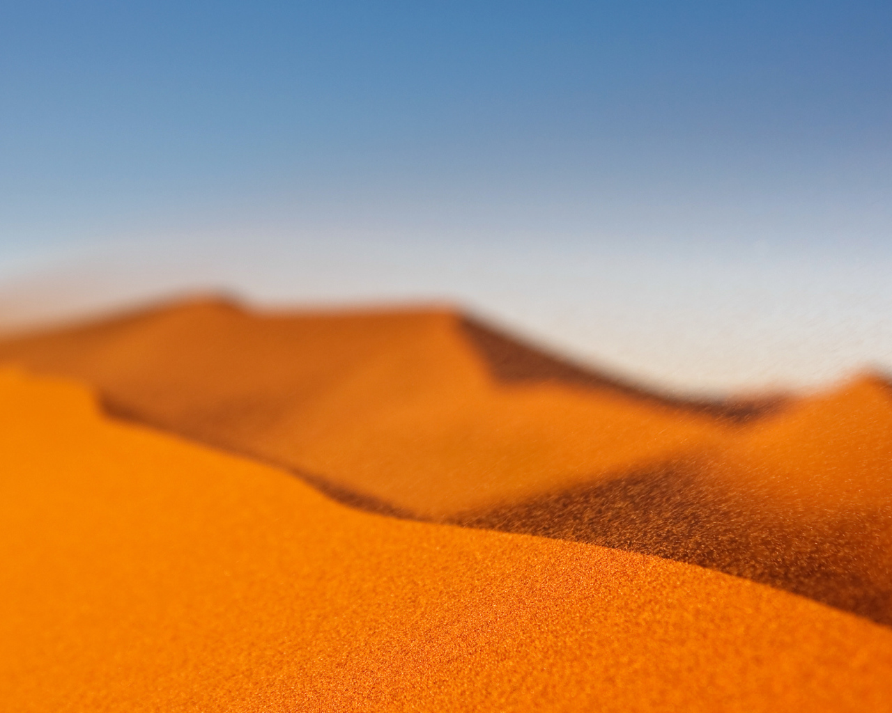 Желтый песок в пустыне под голубым небом
