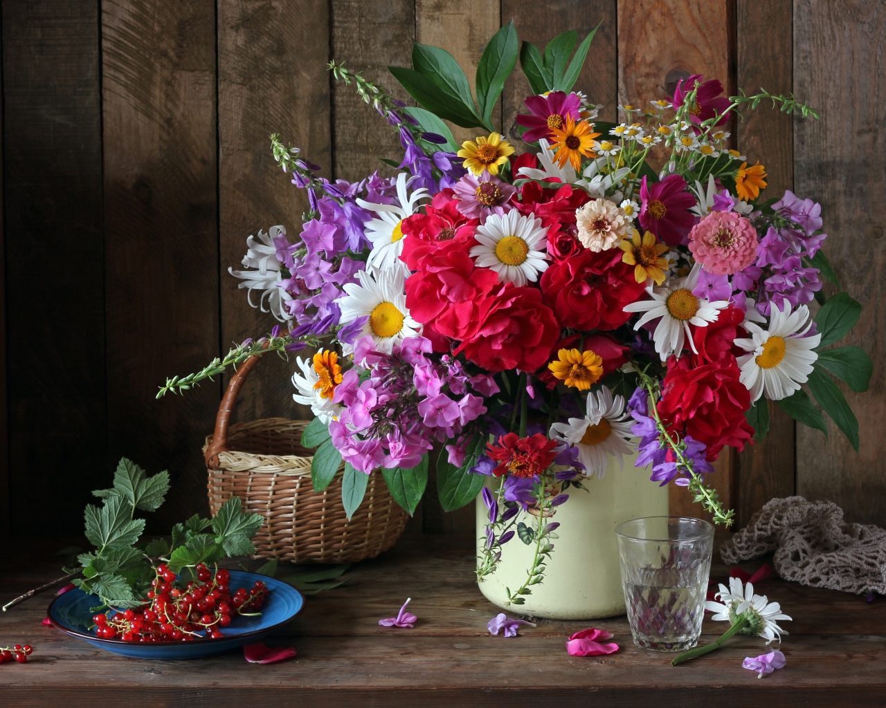Красивый букет стоит на  столе с красной смородиной