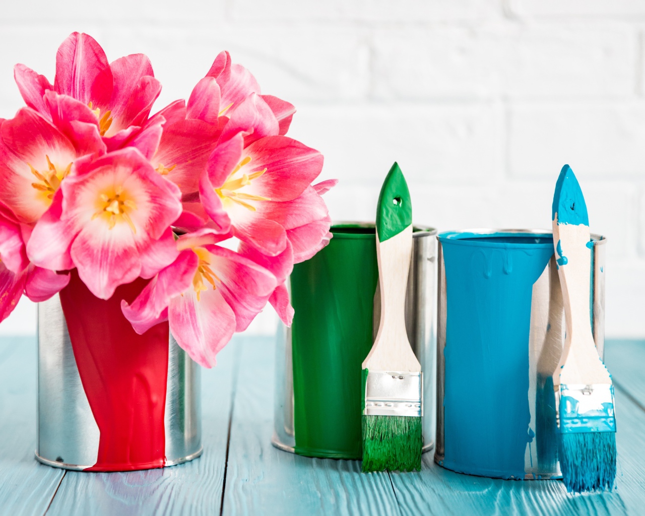 Букет розовых тюльпанов на столе с банками краски и кисточками