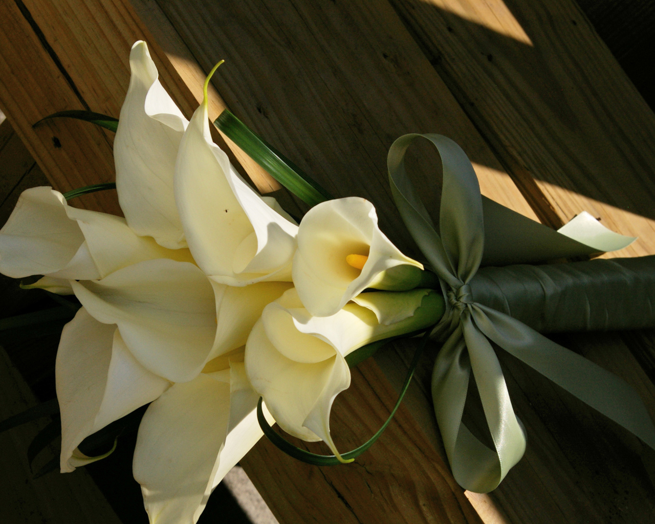 Букет белых калл на деревянной лавке
