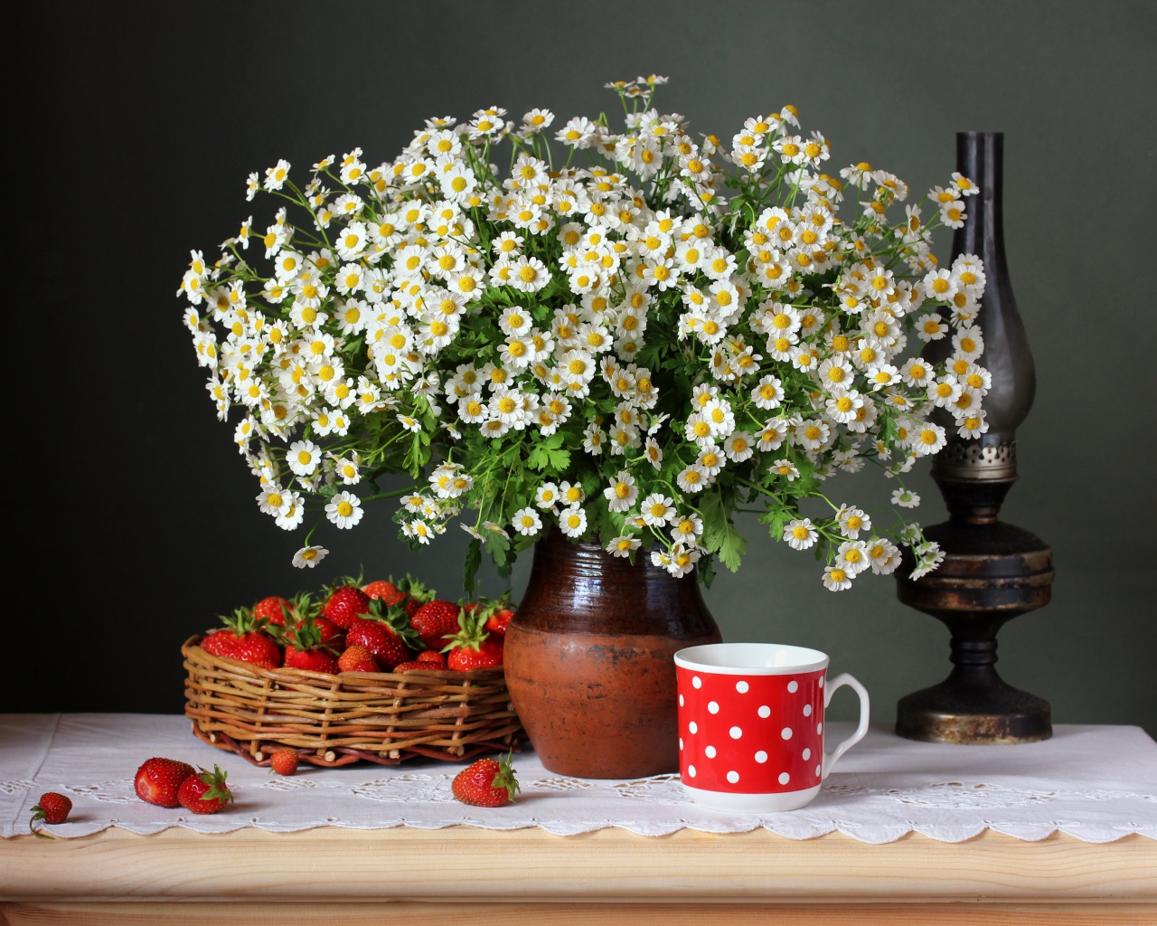 Большой букет ромашек на столе с клубникой