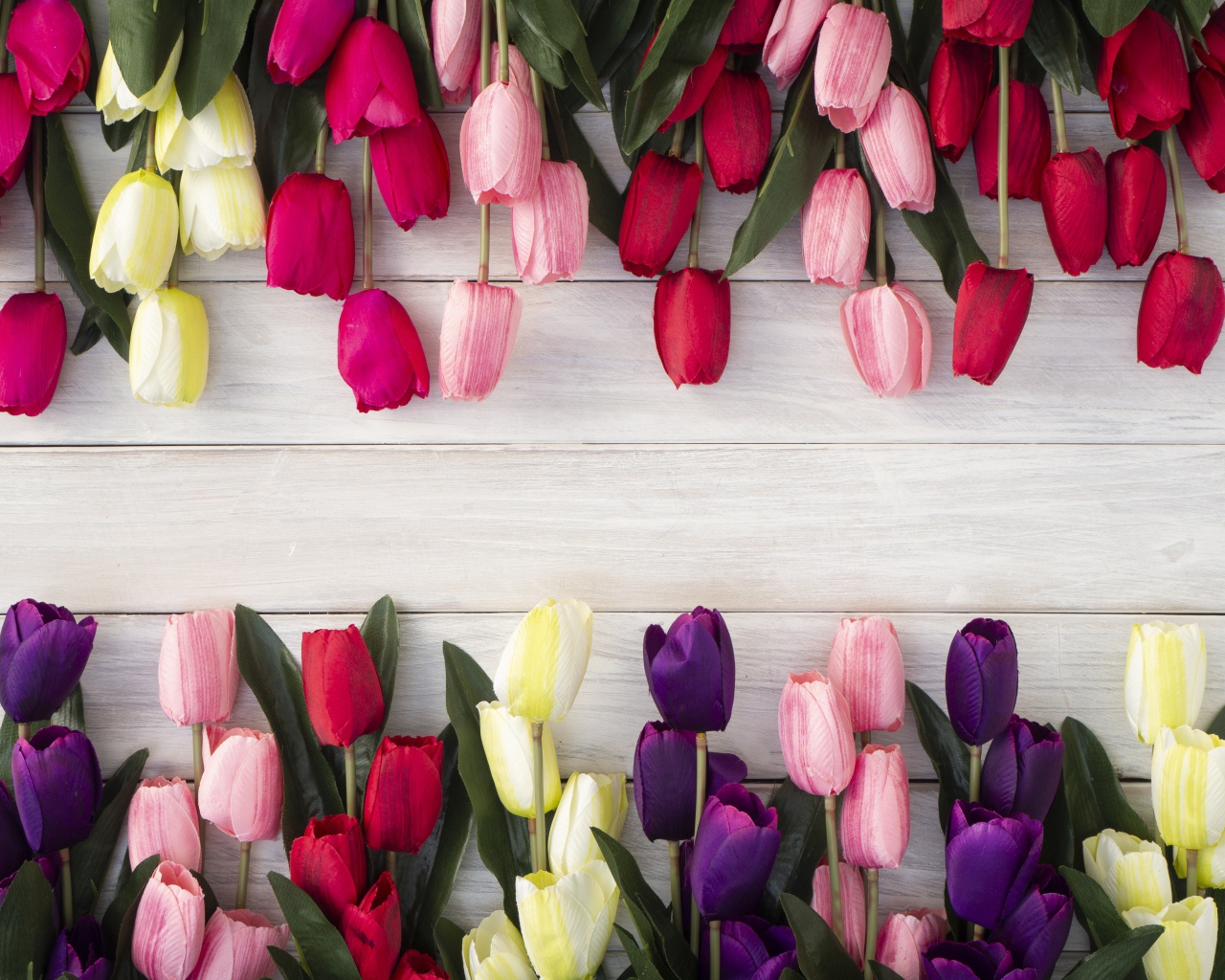 Искусственные разноцветные тюльпаны на деревянной поверхности