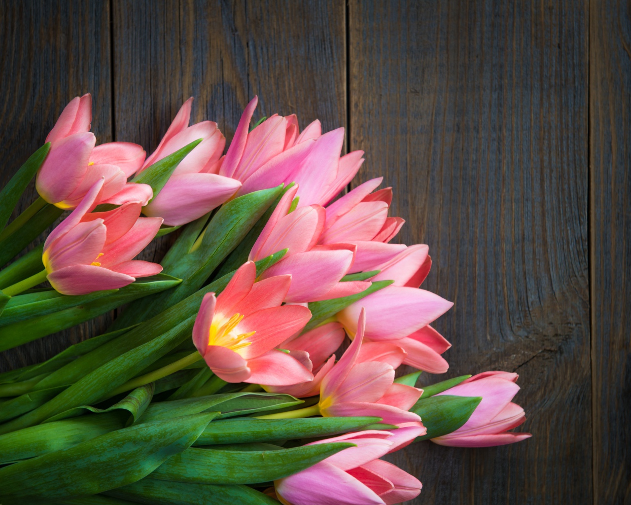 Красивый букет розовых тюльпанов на деревянном столе