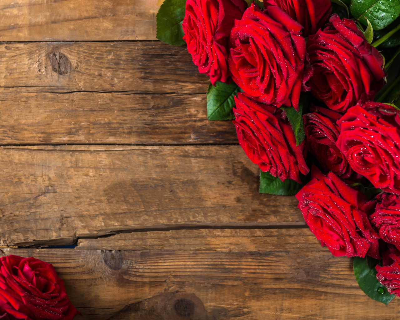 Красивый букет красных роз на деревянном фоне