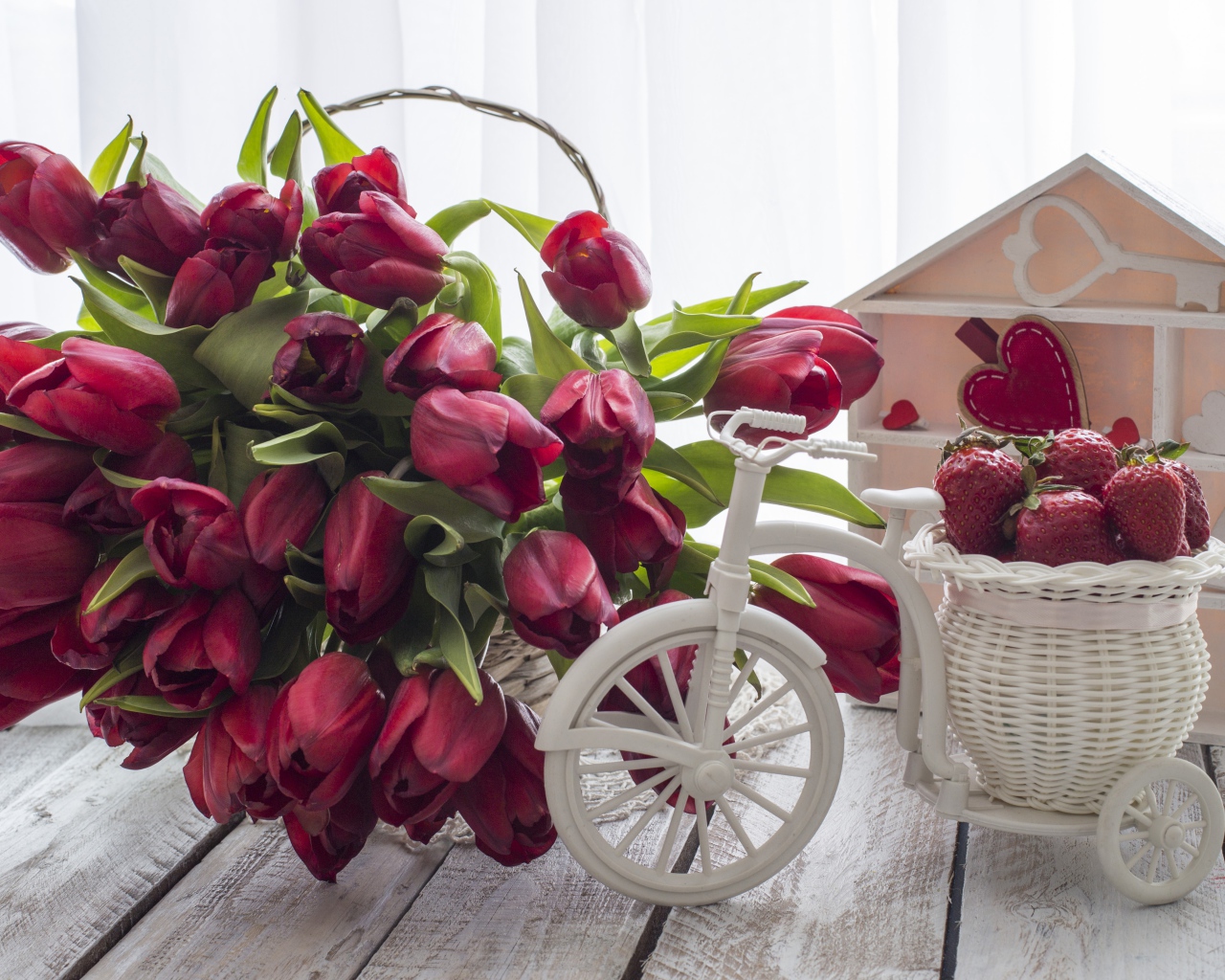 Красивый букет красных тюльпанов на столе с клубникой 