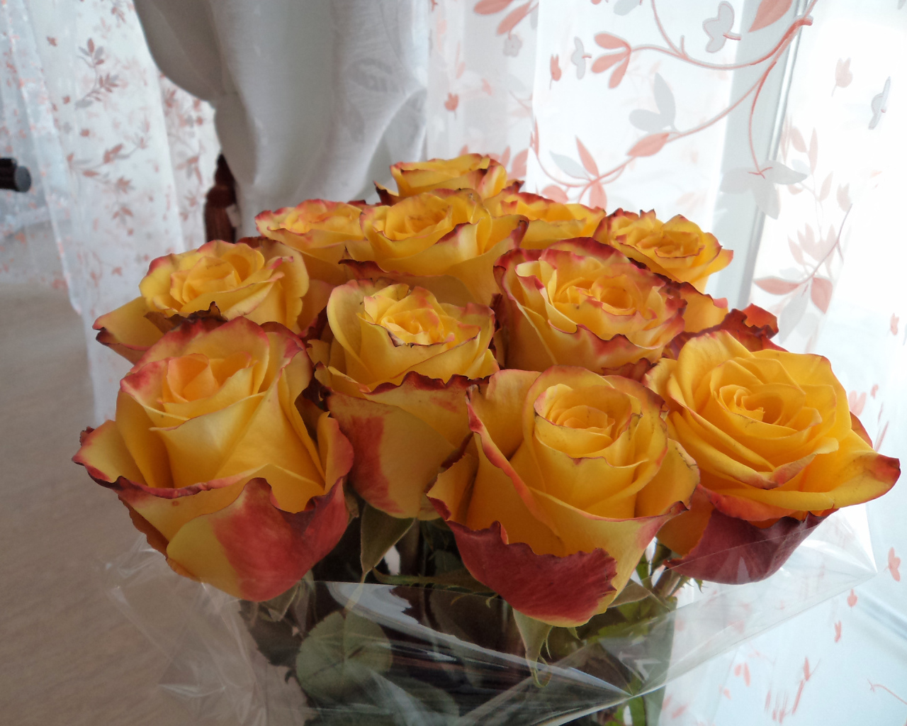 Красивый букет желтых роз в вазе у окна