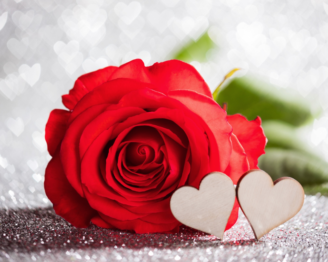 Красивая красная роза с двумя деревянными сердечками