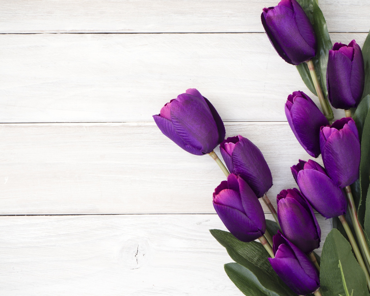 Букет искусственных фиолетовых тюльпанов на деревянном фоне