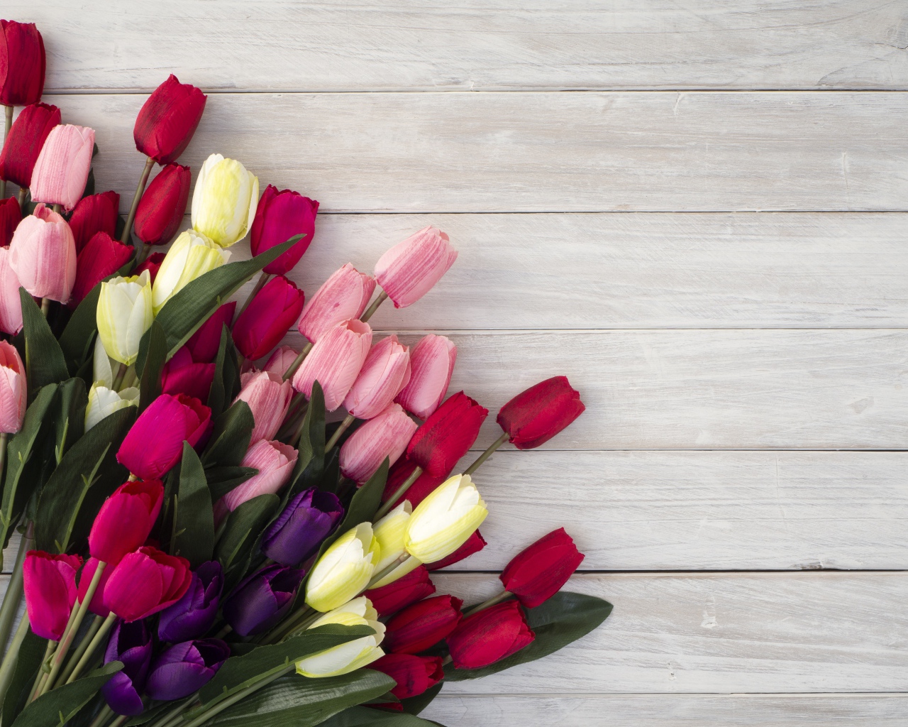Букет искусственных тюльпанов на серой деревянной поверхности