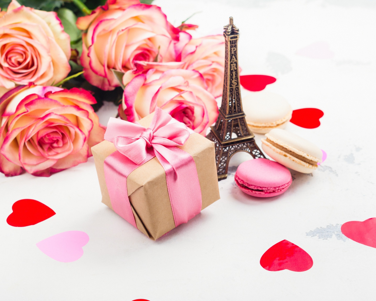 Букет роз на столе с фигуркой Эйфелевой башни и подарком