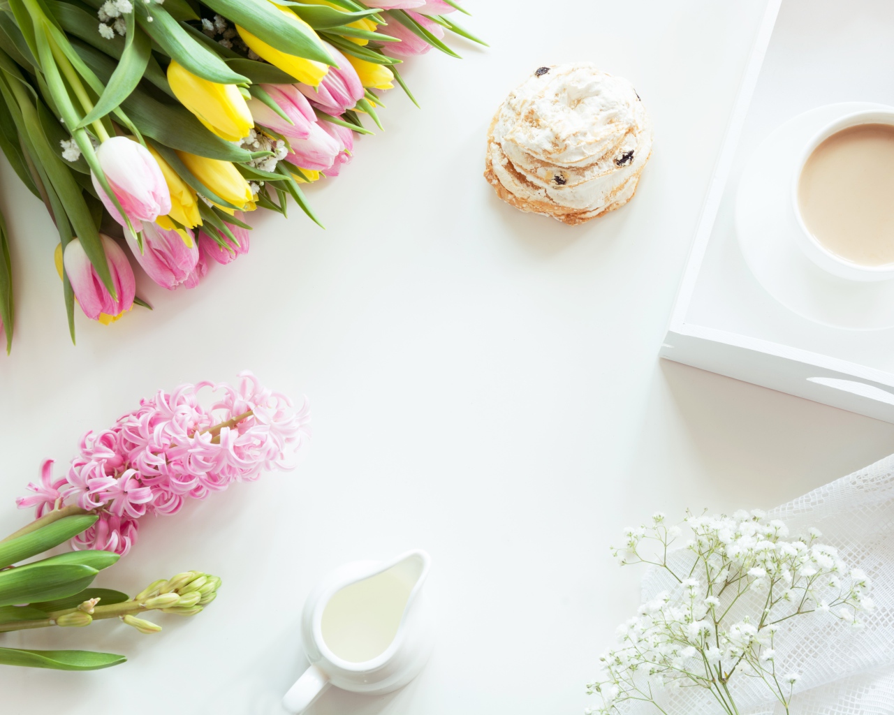 Букет тюльпанов и гиацинт на столе с пирожным и чашкой какао 