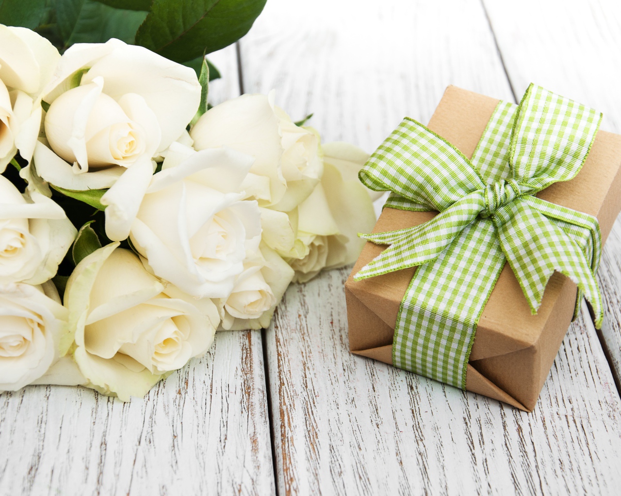 Букет белых роз на столе с подарком