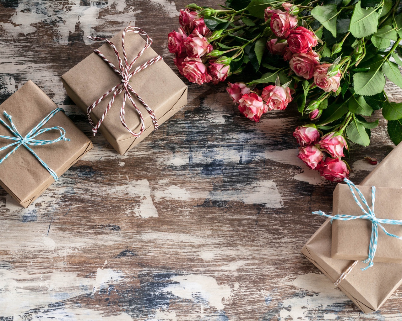Подарочные коробки на деревянной поверхности с букетом роз