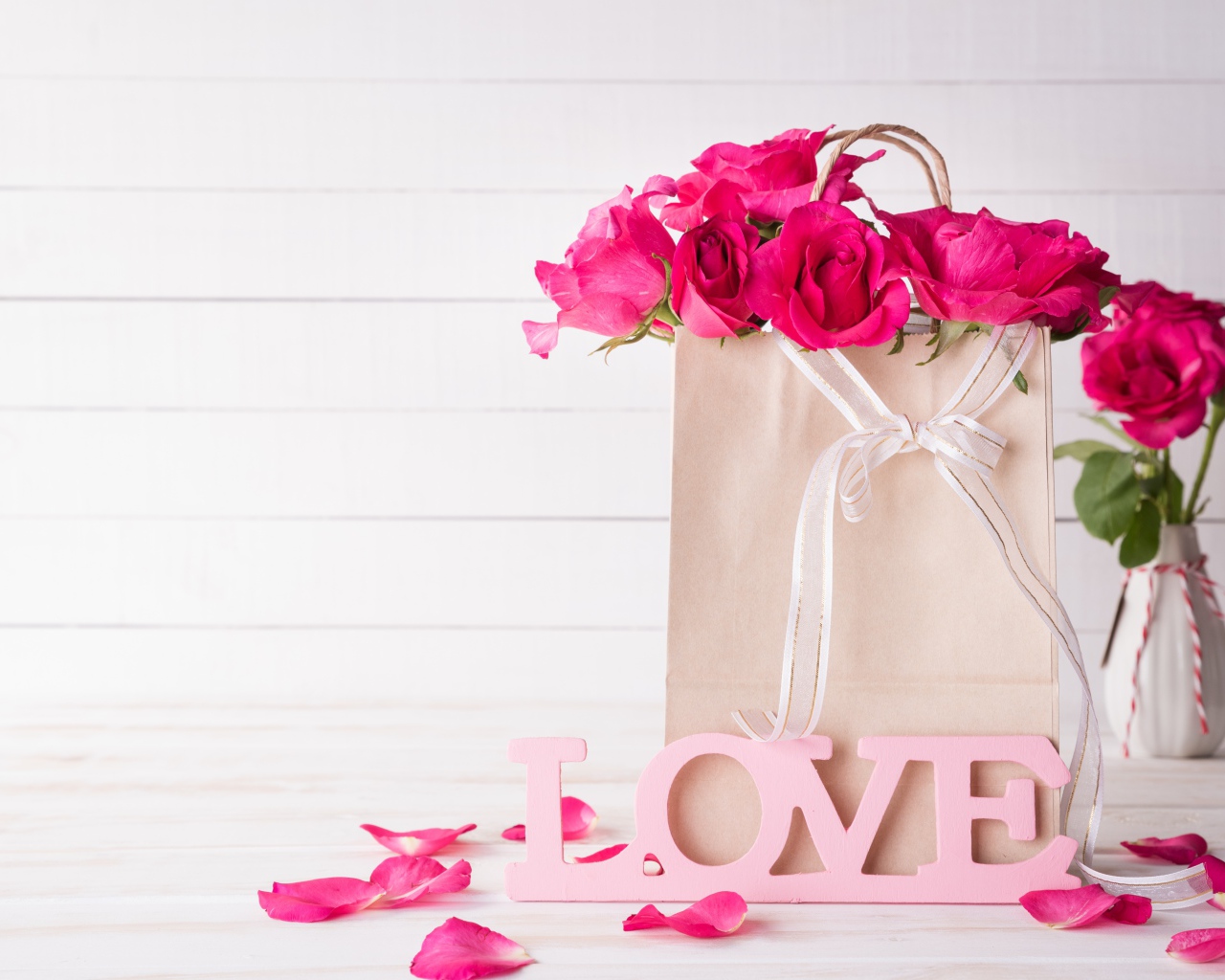 Пакет с розами на столе с надписью Love