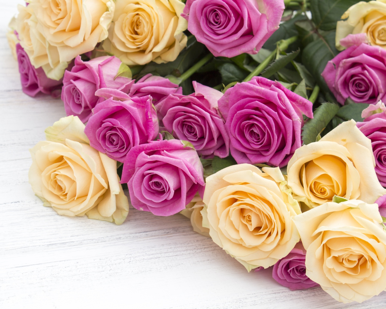 Розовые и белые розы на белом столе 