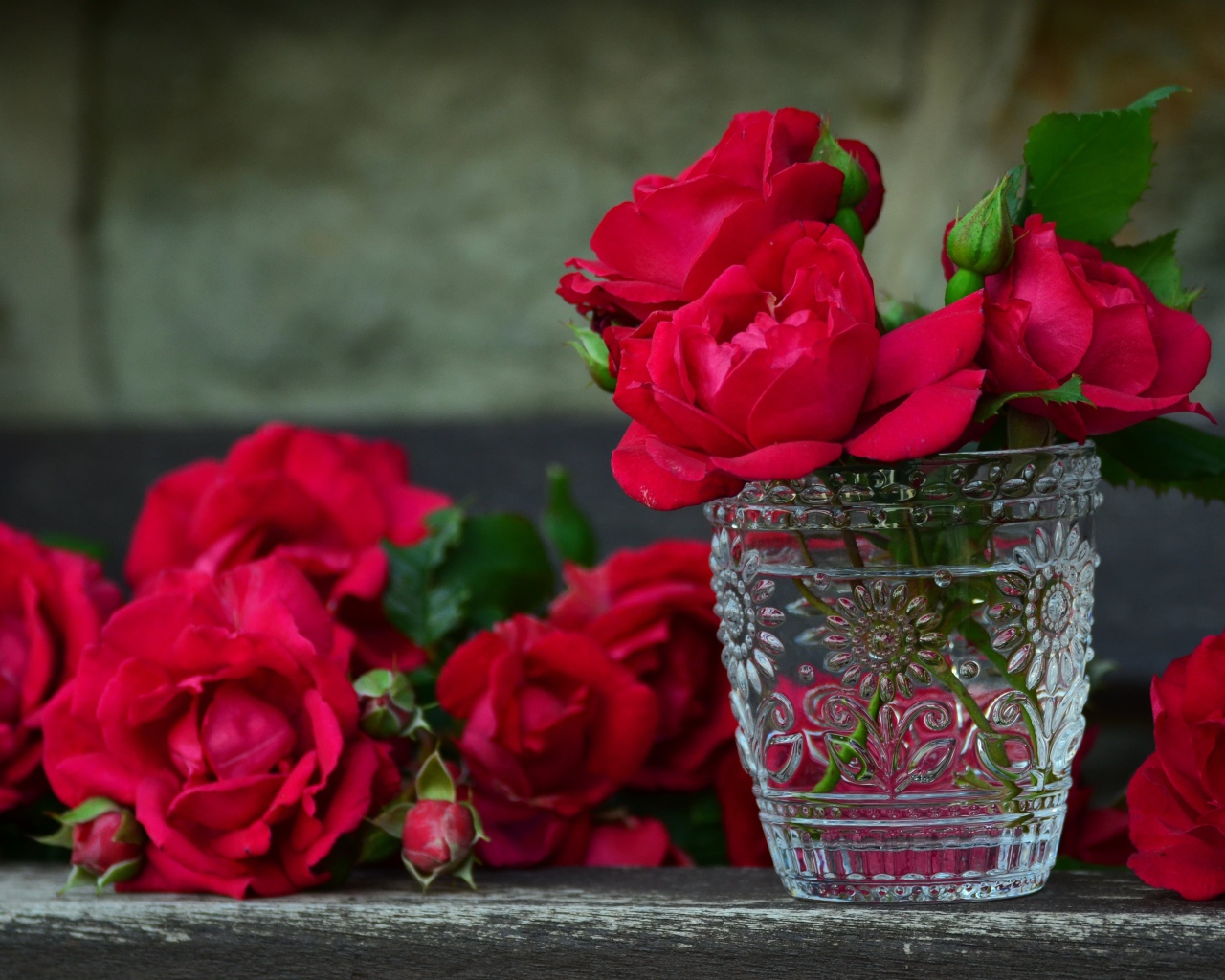 Красные розы в хрустальной рюмке на столе