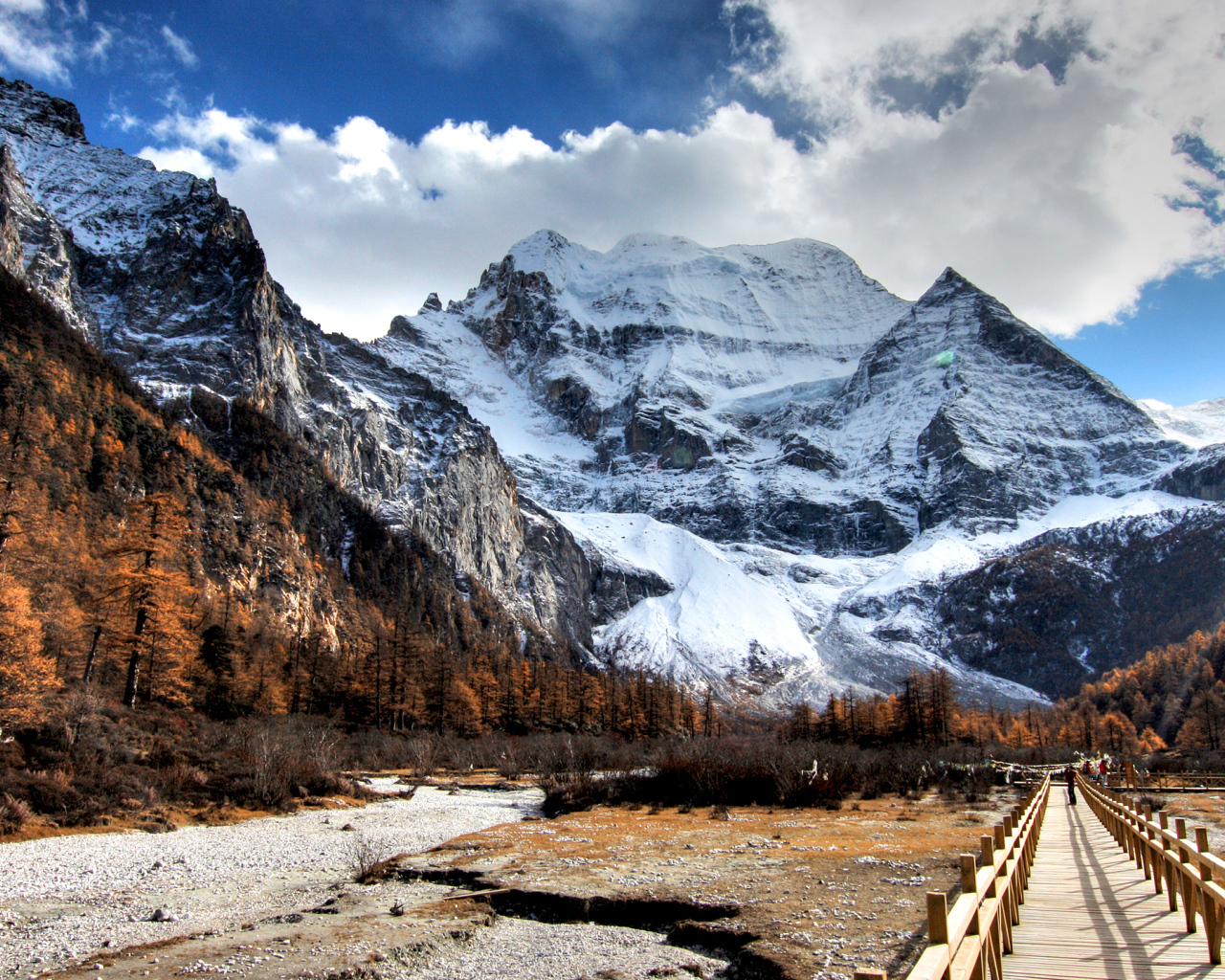 Мост у подножия заснеженных величественных гор