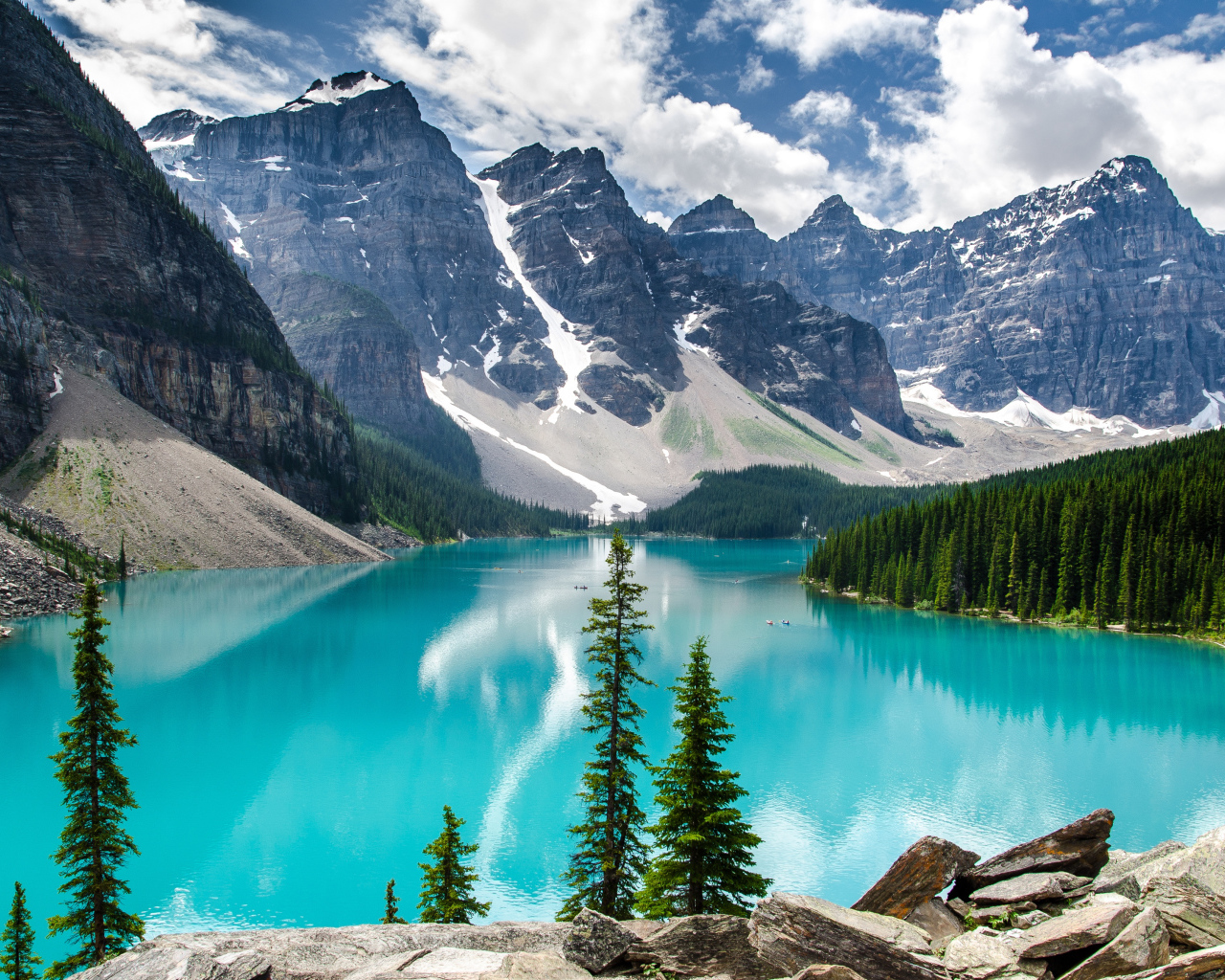 Высокие покрытые снегом горы у озера с голубой водой 