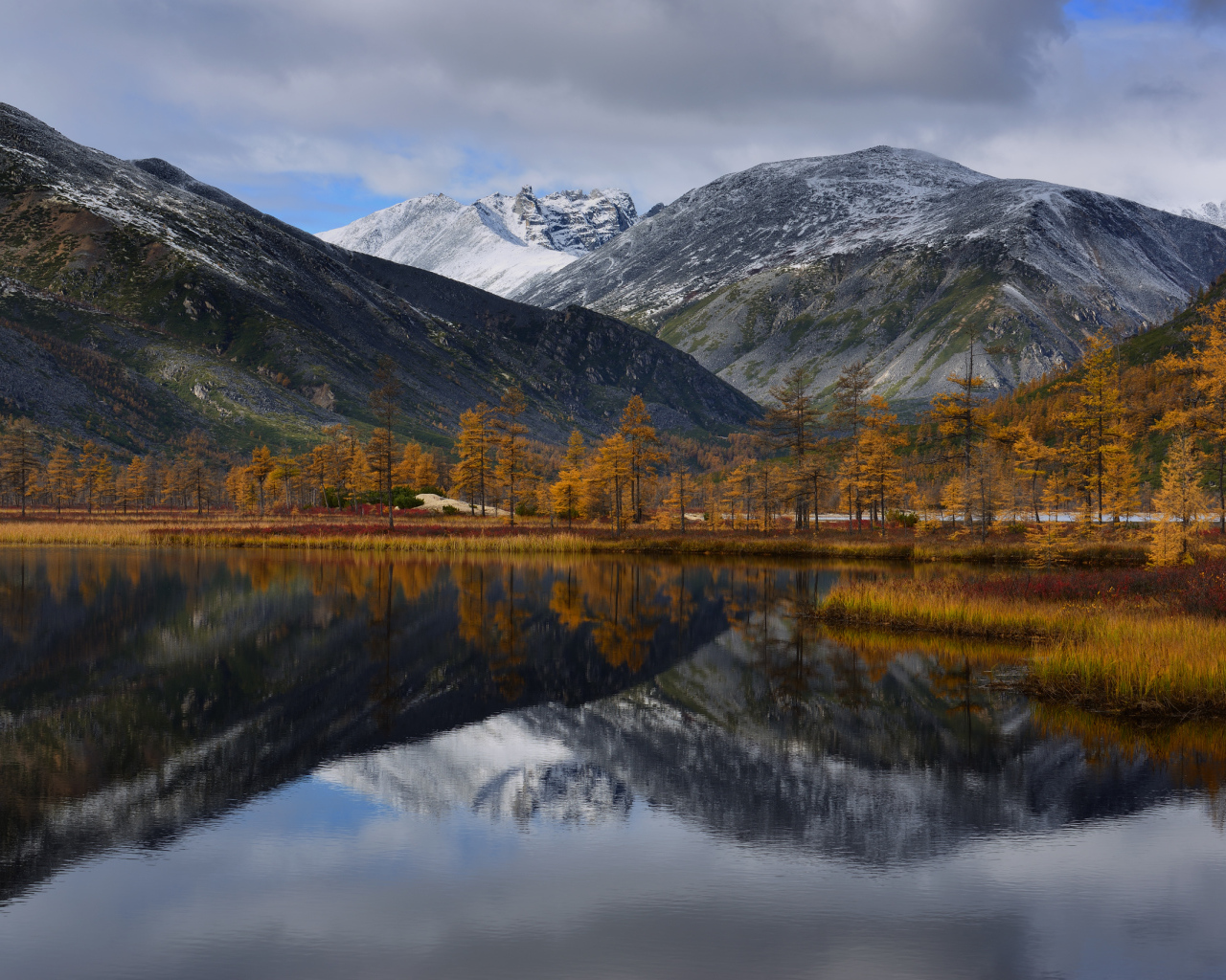 Горы отражаются в глади воды озера осенью
