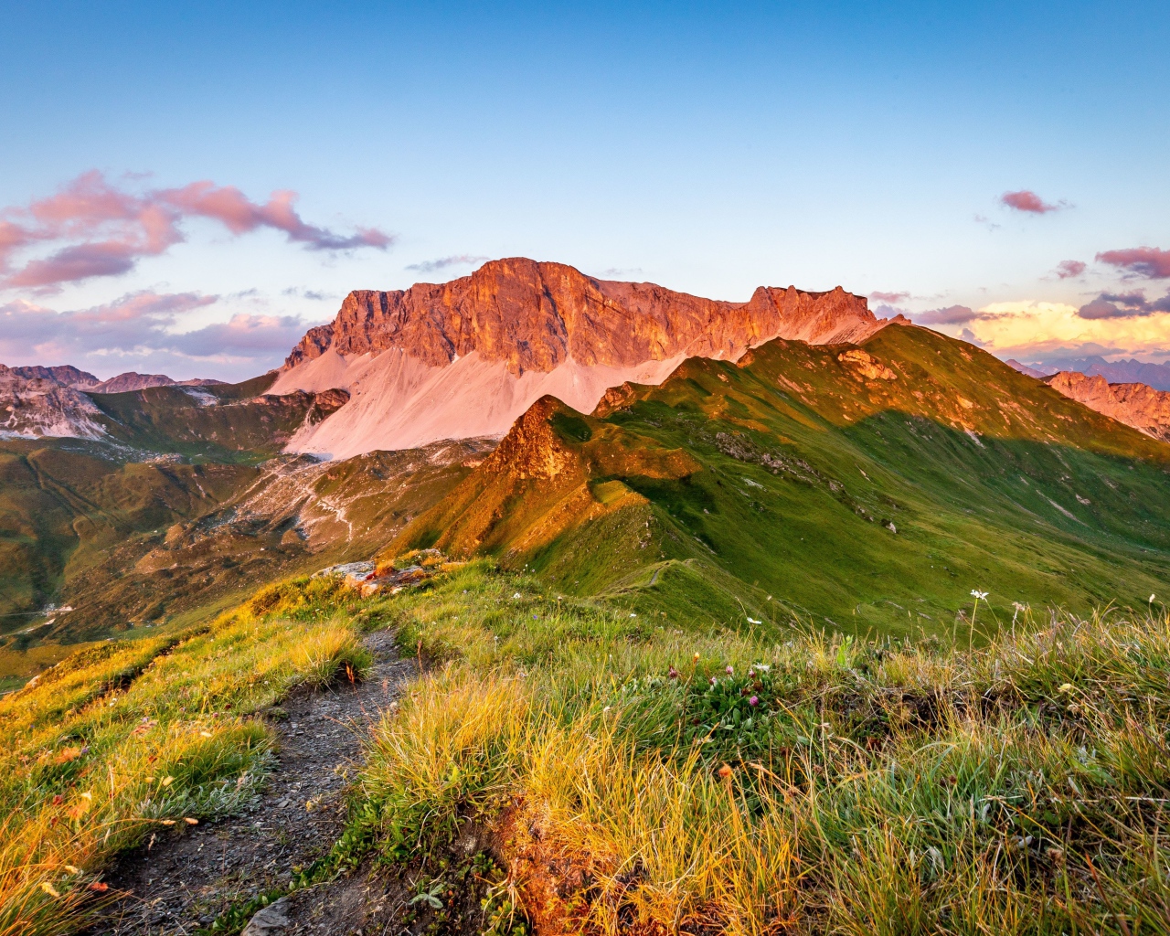 Солнце встает над зелеными горами